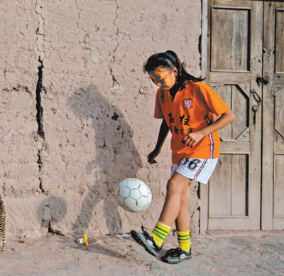 Salah seorang pemain pasukan bola sepak perempuan sedang mempamerkan skil di Sekolah Rendah Bandar Sanhe di bandar Chongqing. (Foto ikhsan pihak sekolah)